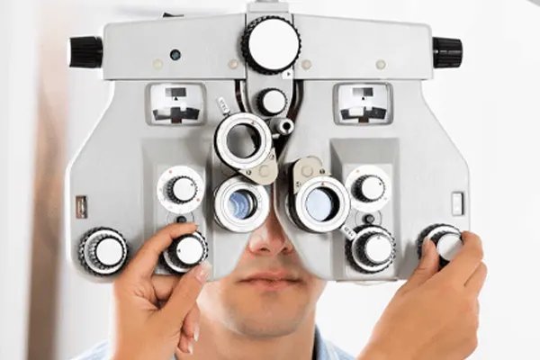 An eye exam with a phoropter in front of the patient's eyes